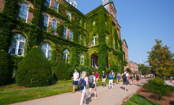 students walk in front of alumni hall