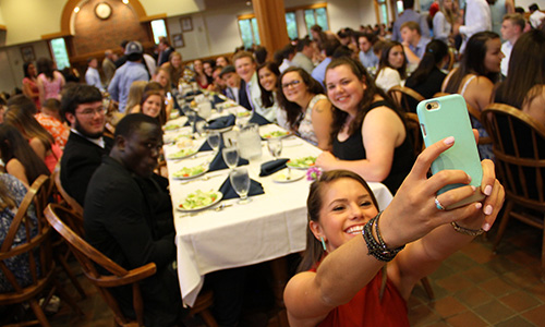student takes a selfie with other students in davison dining hall