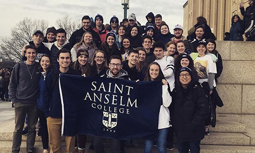 campus ministry students holding saint anselm college pennant