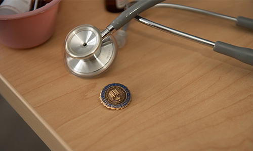 Medical Equipment on table with pin on Saint Anselm seal 
