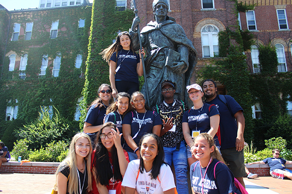 Intercultural Center students with the statue of Saint Anselm