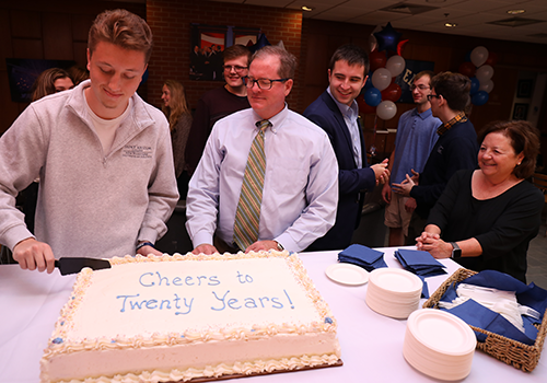 NHIOP staff & students cutting anniversary cake