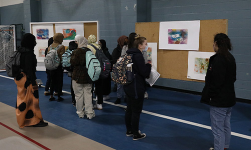 Students and faculty look at poster presentations