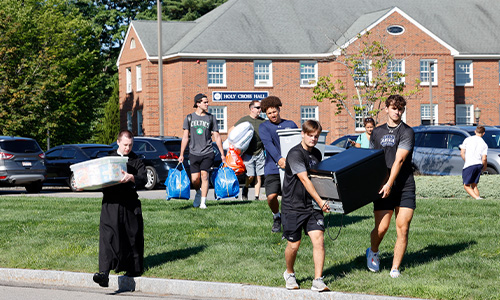 students move in bins to their dorm from the street