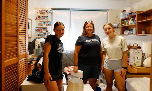 a family stands inside their students' dorm room fully unpacked