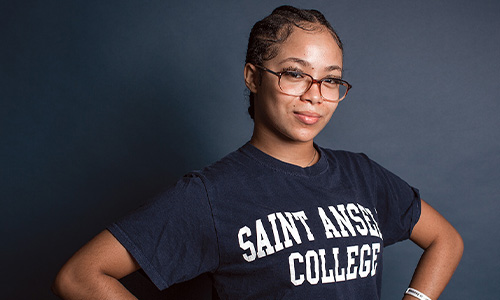 first-generation college student poses in Saint Anselm College shirt