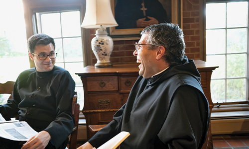 Br. Thomas and Br. Amadeus laugh in chairs