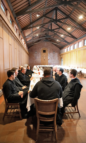 monks eat around a table