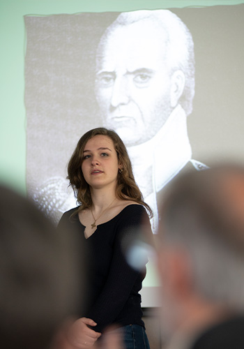 student speaks in front of a projector