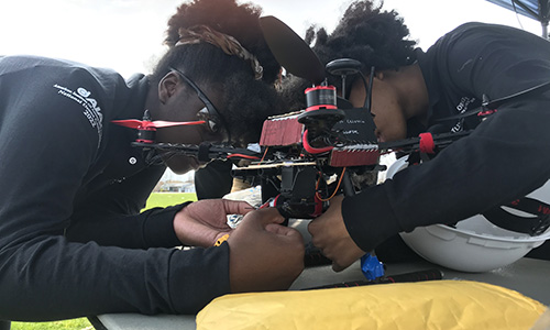 two students work on a drone