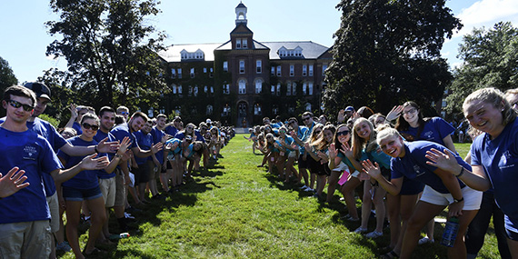 students line up along the sides of a pathway to alumni hall