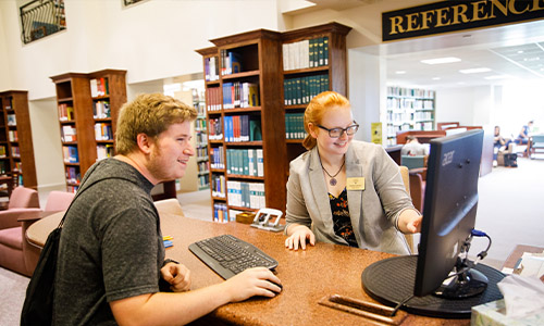 student and staff at the reference desk