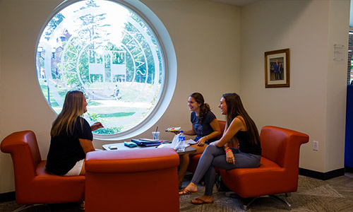 students chatting in front of a window