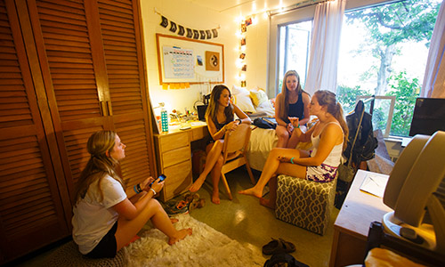 freshmen talking at a desk in their dorm