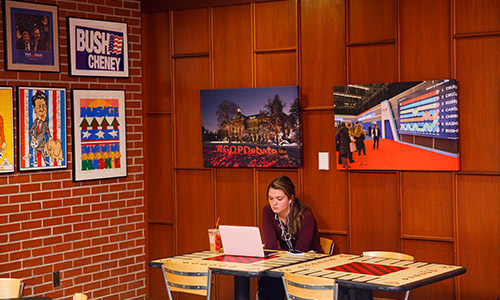 student on a laptop in the NHIOP lobby
