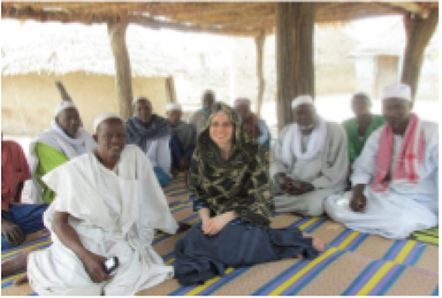 Professor sits with members of the town of Medina Gounass in Senegal