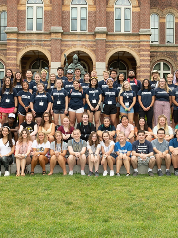 Group of students smiling in front of alumni hall 