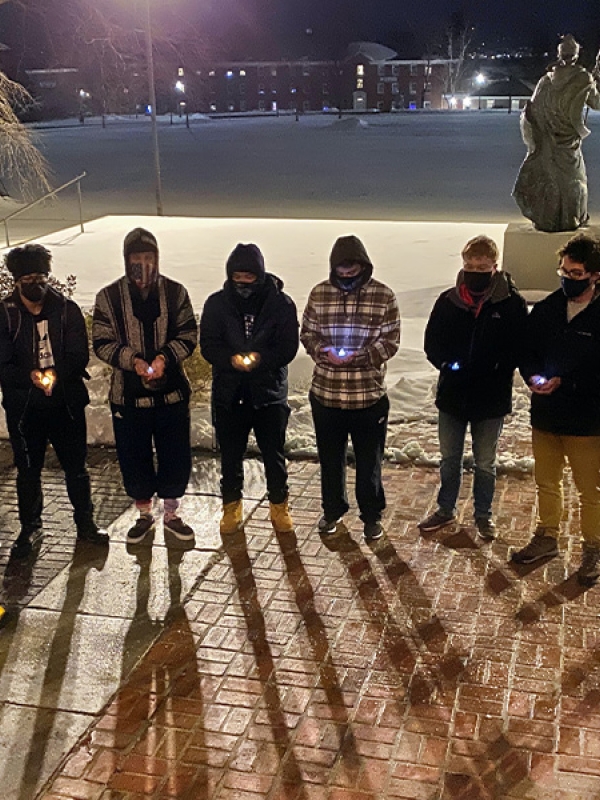 students and staff hold a vigil on the front steps of Alumni Hall