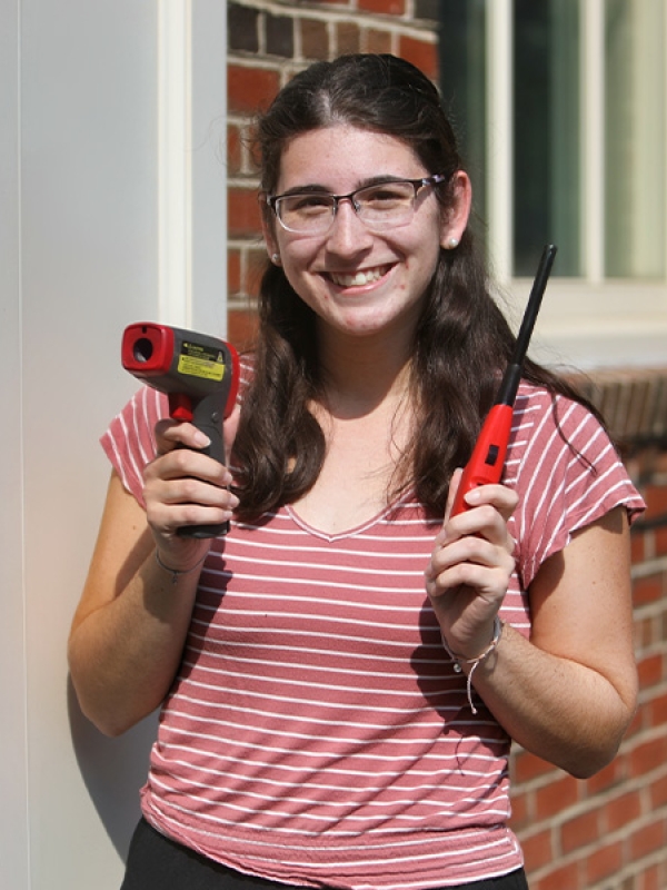 student holds lighter in front of building