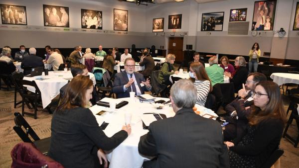people sit at tables in the NHIOP event space