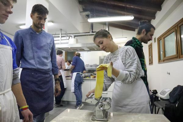 A student rolling and cutting pasta