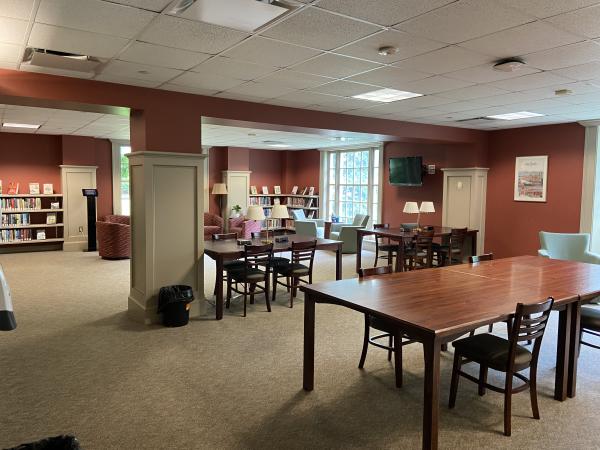 Reading Room with large group study tables, soft armchairs, windows, and Leisure Reading collection