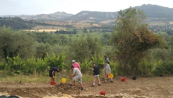students dig atop an italian landscape