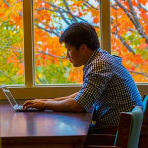 student works on a laptop in the library