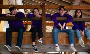 Students hang off an indoor railing