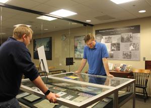 Students standing over exhibit