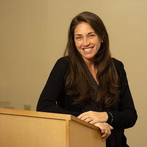 Kaitlyn Clarke '09 sits at a podium