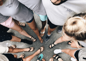 Students standing in a circle with their feet in the center