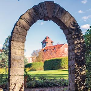 A view of the Alumni Hall bell tower from the monastery graveyard arch