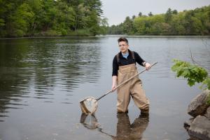 Shannon O'Leary standing in a river holding a net