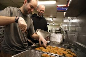 Monk watches as a worker in Davision prepares food.