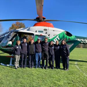 EMS team posing in front of a medical helicopter