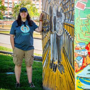 Jyl Dittbenner ’97 standing next to one of her murals