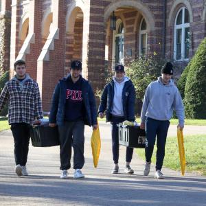 Students carrying thanksgiving basket materials