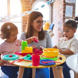 Teacher surrounded by young students in a home care setting