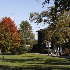 Fall image of a college campus with individuals walking.