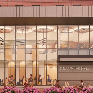 Front facade of a building with a large window showing individuals seated inside and the name "Grappone Hall" on the exterior. 