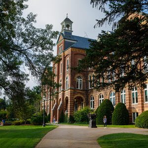 Front facade of a large campus building (Alumni Hall) with a cupola