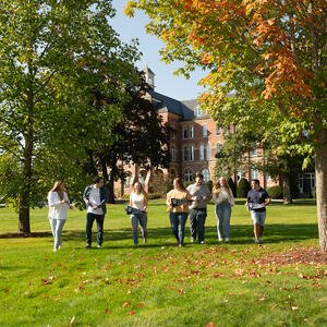 Students walking with banners on a college campus