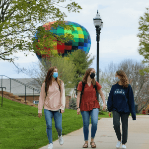 students walking in front of a hot air balloon