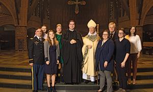 Brother Francis McCarty, O.S.B. ’10 and his parents and siblings stand with Abbot Mark Cooper, O.S.B. ’71.