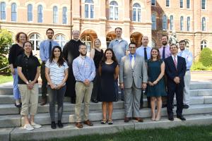 New faculty standing on the steps in front of Alumni Hall