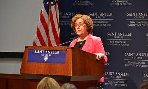 Elaine Weiss speaks from a podium at the NHIOP
