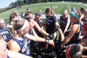 Field Hockey team huddles on the field