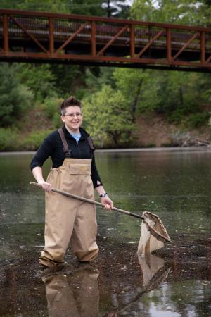 Shannon O'Leary standing in a river holding a net