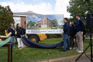 Student unveiling the concept art for the new building